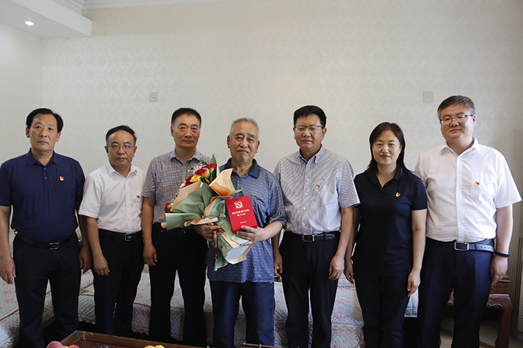 圖片1：學校領(lǐng)導(dǎo)到楊春同志的家中走訪慰問并與他合影留念.JPG