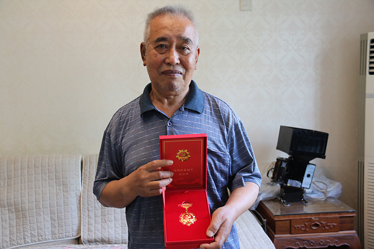 圖片3：“光榮在黨50年”紀念章講述老黨員的光輝歷程，閃耀共產(chǎn)黨人的精神榮光.JPG